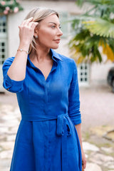 Anna Bey in blue linen dress looking sideways 