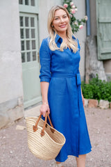 Anna Bey smiling in her signature blue linen shirt dress 