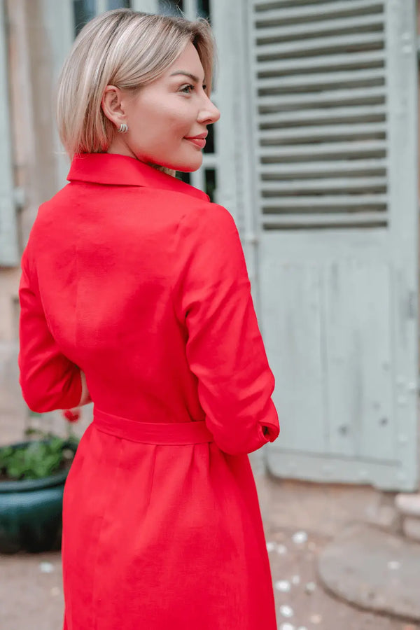 Anna Bey in a red linen dress looking sideways