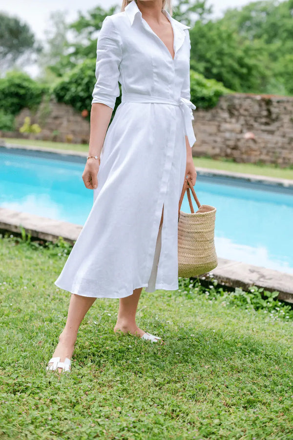 Close-up of Anna Bey in a white linen dress standing in a garden