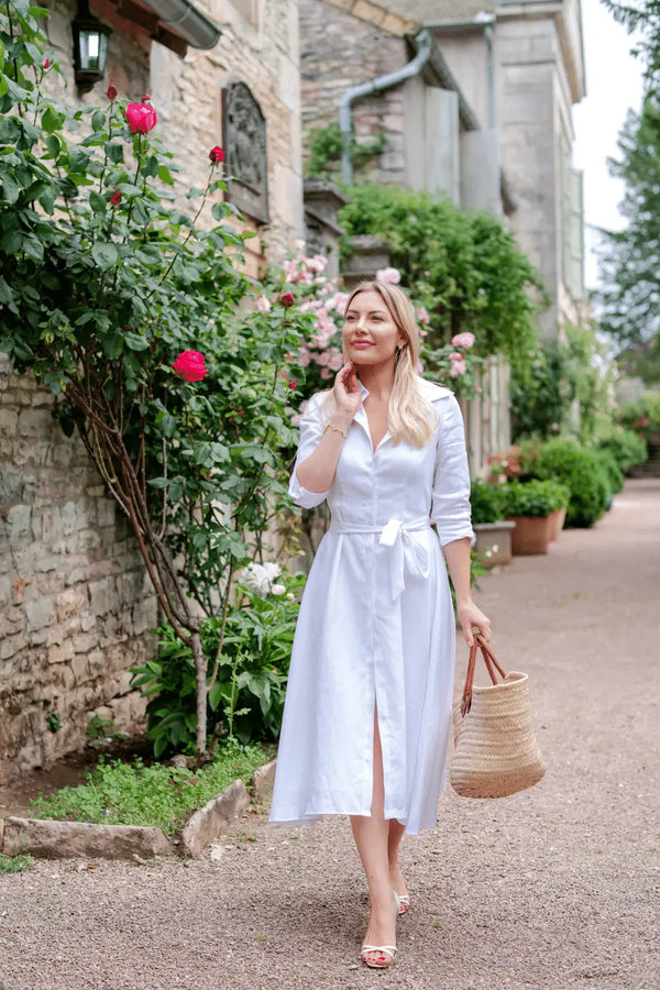 Anna Bey standing in a garden in her signature linen dress in white