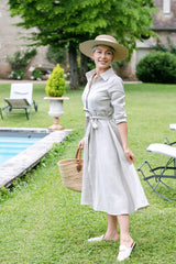Anna Bey smiling and looking sideways in her signature oatmeal linen dress 
